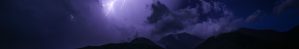 A jagged bolt of lightning illuminates dark clouds over silhouetted mountains at night, casting a purple-blue hue across the sky.
